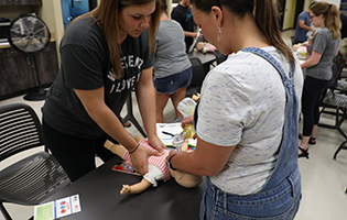 Two Women Performing CPR on Child Dummy