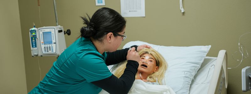 Female Nursing Student Examining a Patient