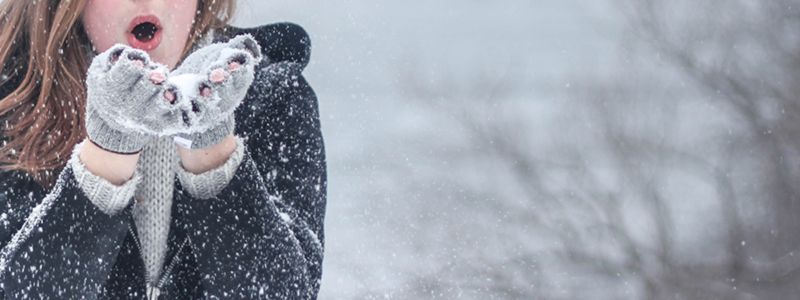 A girl blowing snow into the air