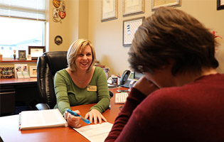 Two Women Facing Each Other at a Desk