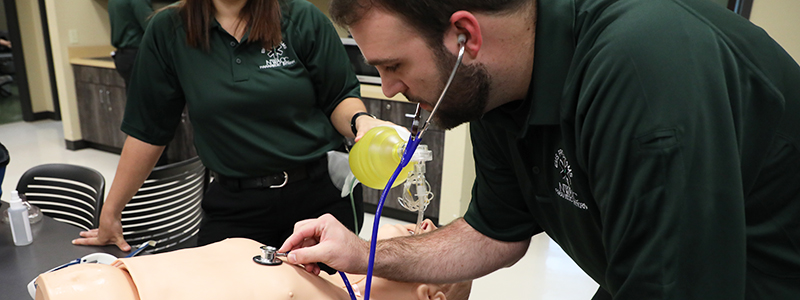 Male Student Using a Stethoscope on a Dummy