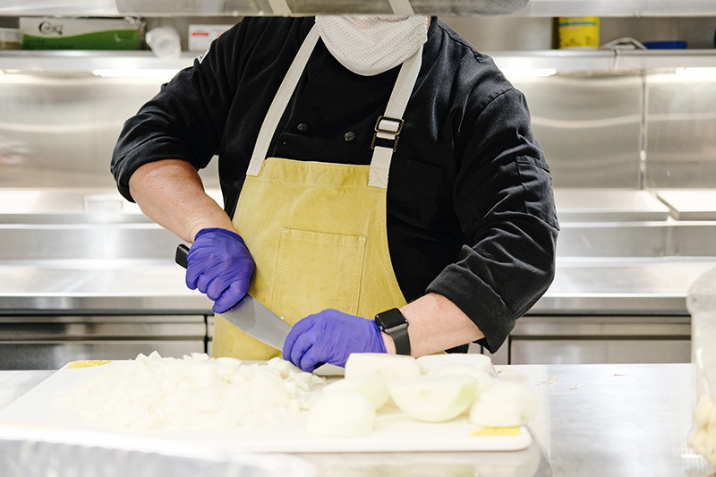 Chef Cutting Onions Wearing Mask and Gloves