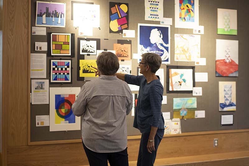 Two Women Viewing Art on the Wall