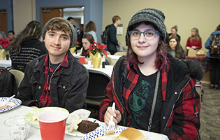 Male and female student eating at a table
